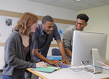 Photo of students looking at a computer. Links to Gifts from Retirement Plans